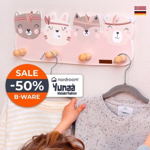 Könnte beinhalten: Ein rosa Holz-Kleiderhaken mit vier tierförmigen Haken. Die Haken sind in Form eines Bären, eines Fuchses, eines Kaninchens und einer Katze. Der Kleiderhaken hat ein Verkaufsschild mit der Aufschrift "SALE -50% B-WARE". Der Kleiderhaken ist auch mit "nordroom® Yunaa Kleiderhaken" beschriftet.