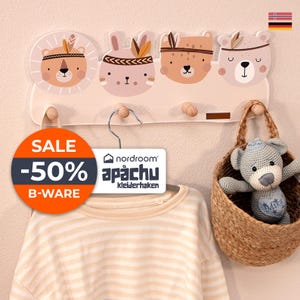 Könnte beinhalten: Ein Wand-Kleiderhaken aus Holz mit vier Haken in Form von Tiergesichtern: ein Löwe, ein Kaninchen, ein Fuchs und ein Bär. Der Kleiderhaken ist in Pastellfarben lackiert und hat einen hellrosa Hintergrund. Der Text "nordroom" und "apächu Kleiderhaken" ist auf einem weißen Etikett gedruckt, das am Kleiderhaken hängt. Ein Sale-Schild mit dem Text "SALE -50% B-WARE" befindet sich in der linken unteren Ecke des Bildes. Ein gestreiftes Hemd hängt am Kleiderhaken, und ein Weidenkorb mit einem gehäkelten Teddybär hängt rechts am Kleiderhaken.