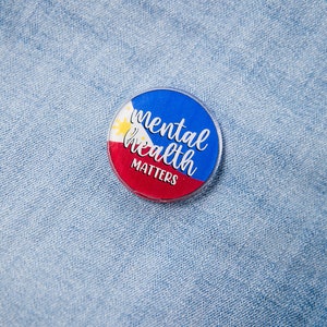 Puede incluir: Un botón azul y rojo con la bandera de Filipinas y el texto "mental health matters" sobre un fondo de mezclilla azul.