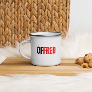 May include: White enamel mug with a black and red design that says "OFFRED".