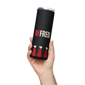 May include: Black stainless steel tumbler with a white background and the text "OFFRED" in red. Three figures in red robes are at the bottom of the tumbler.
