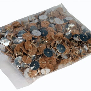 May include: A clear plastic bag filled with a large quantity of small, round, cork candle holders. Each holder has a silver-coloured metal base and a small, thin wick.