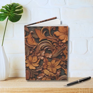 May include: A brown and gold journal with a floral design. The design features intricate carvings of flowers and leaves.