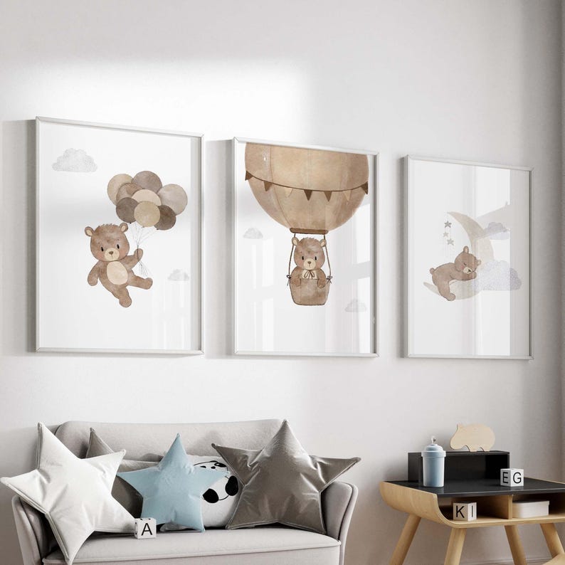 May include: Three framed prints featuring watercolour illustrations of brown bears. The first print depicts a bear holding balloons, the second shows a bear in a hot air balloon, and the third shows a bear sleeping on a crescent moon.