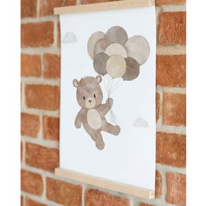 May include: A watercolor illustration of a brown teddy bear holding onto a bunch of brown, beige, and white balloons. The bear is flying in the air with clouds in the background.