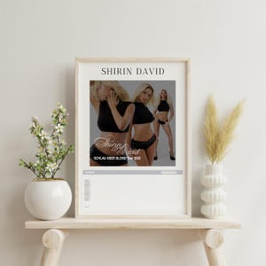 Könnte beinhalten: Ein Poster mit weißem Hintergrund und schwarzem Text, der "SHIRIN DAVID" in Fettdruck lautet. Das Poster zeigt ein Foto von drei Frauen in schwarzer Kleidung. Der Text "SCHLAU ABER BLOND Tour 2025" befindet sich unter dem Foto.