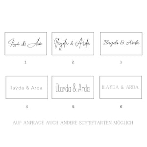 Puede incluir: Sobre un fondo blanco, se muestran seis ejemplos de los nombres "Ilayda & Arda" en diferentes fuentes. El texto "AUF ANFRAGE AUCH ANDERE SCHRIFTARTEN M&Ouml;GLICH" est&aacute; en la parte inferior. Las fuentes var&iacute;an de cursiva a letras de bloque.