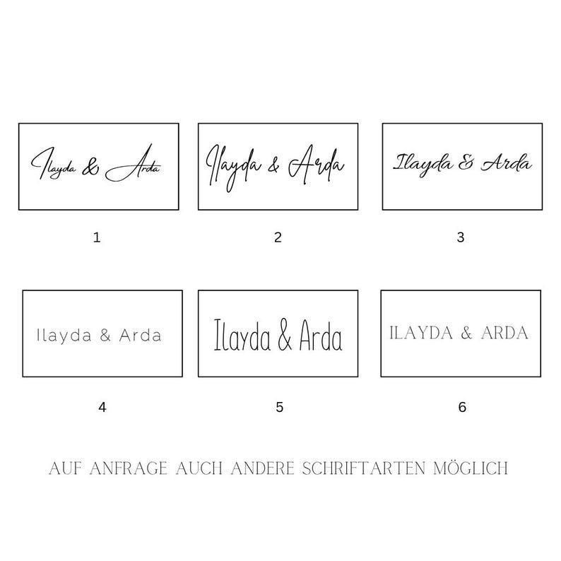 Puede incluir: Sobre un fondo blanco, se muestran seis ejemplos de los nombres "Ilayda & Arda" en diferentes fuentes. El texto "AUF ANFRAGE AUCH ANDERE SCHRIFTARTEN M&Ouml;GLICH" est&aacute; en la parte inferior. Las fuentes var&iacute;an de cursiva a letras de bloque.