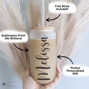 May include: A frosted glass tumbler with a bamboo lid and a straw. The tumbler is personalized with the name "Melissa" in black script. The tumbler is filled with a light brown liquid.