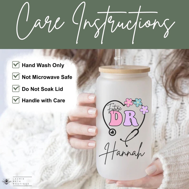 May include: White tumbler with a bamboo lid and a straw. The tumbler has a pink and purple heart with the text "Future DR" and a stethoscope. The name "Hannah" is written below the heart. Care instructions are listed on the left side of the image: Hand Wash Only, Not Microwave Safe, Do Not Soak Lid, Handle with Care.