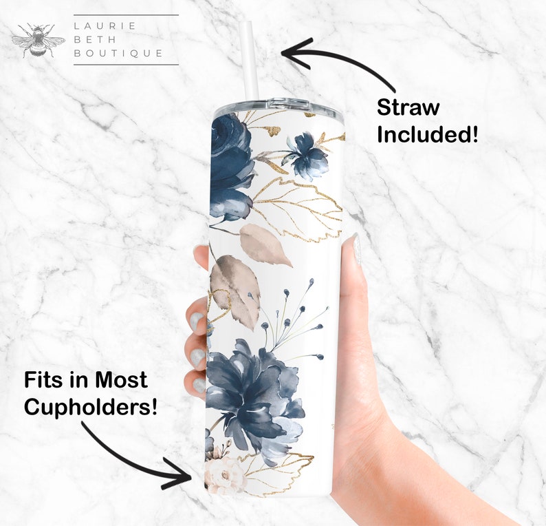 May include: White tumbler with a blue and gold floral design. The tumbler has a lid and a straw. The text "Straw Included!" is written on the right side of the image. The text "Fits in Most Cupholders!" is written on the left side of the image.
