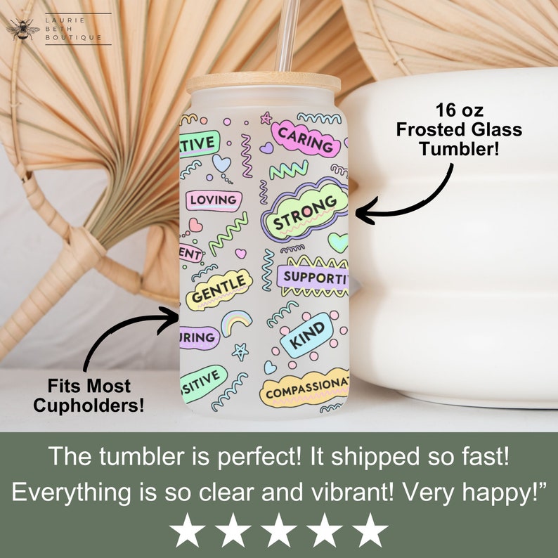Puede incluir: Un vaso de vidrio esmerilado de 473 ml con tapa de bamb&uacute; y una pajita. El vaso tiene un fondo blanco con palabras y dise&ntilde;os coloridos, incluyendo "caring", "strong", "gentle", "kind" y "compassionate".