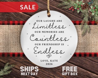 May include: A round white ceramic ornament featuring black text that reads: OUR LAUGHS ARE LIMITLESS, OUR MEMORIES ARE COUNTLESS, OUR FRIENDSHIP IS ENDLESS, LOVE, KATE, 2026. The ornament includes a small heart icon and a gold hanging ribbon.