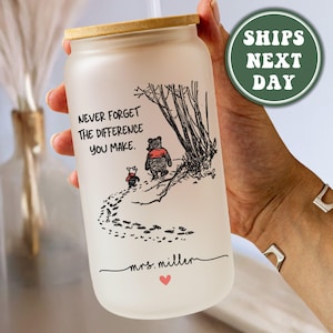May include: A frosted glass tumbler with a bamboo lid and a straw. The tumbler has a Winnie the Pooh quote that reads "Never forget the difference you make." and a small heart at the bottom. The tumbler is personalized with the name "Mrs. Miller".