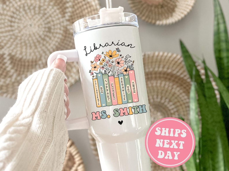 May include: White tumbler with a black and white design of a stack of books with flowers and the text "Librarian Ms. Smith".