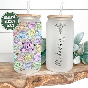 May include: Two white tumblers with bamboo lids and straws. One tumbler has a colorful design with the text "Surgical Tech Daily Affirmations" and the other tumbler has a medical caduceus symbol and the text "Melissa CST".