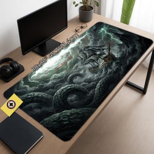 May include: A rectangular mouse mat featuring a fantasy illustration of a ship under attack by a giant sea creature in a stormy sea. The mat measures 45.7cm x 91.4cm. The design incorporates dark blues, greens, and whites.