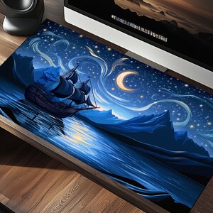 Puede incluir: Un ratón de ordenador azul y negro con una escena de cielo nocturno estrellado y un barco navegando en el agua. La luna es una media luna y hay montañas en el fondo.
