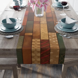 May include: A rectangular table runner with a patchwork design of various wood grain patterns in shades of brown, tan, and green. The runner is placed on a wooden table set with tableware, wine glasses, and a vase of pink flowers.