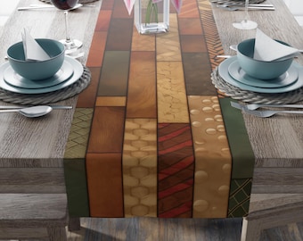 May include: A table runner featuring a patchwork design of wood grain patterns in brown, tan, and green. The runner is on a wooden table set with tableware, wine glasses, and a vase of pink flowers. The table is set for a meal.