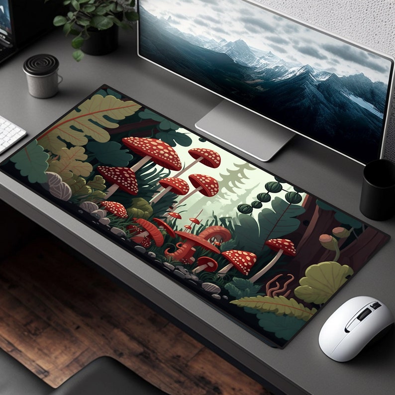May include: A colourful mouse mat with a forest scene featuring red and white mushrooms, green leaves, and brown tree trunks. The mouse mat is rectangular and has a black border.
