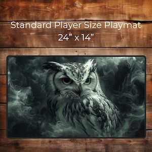 May include: A rectangular playmat with a detailed illustration of an owl, set against a smoky, dark background. The playmat is 24 inches by 14 inches and features the text "Standard Player Size Playmat". The owl has green eyes.