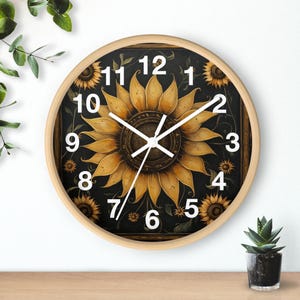 May include: A round wall clock featuring a sunflower design. The clock face is black with white numbers and hands. The sunflower is yellow and brown against a black background.
