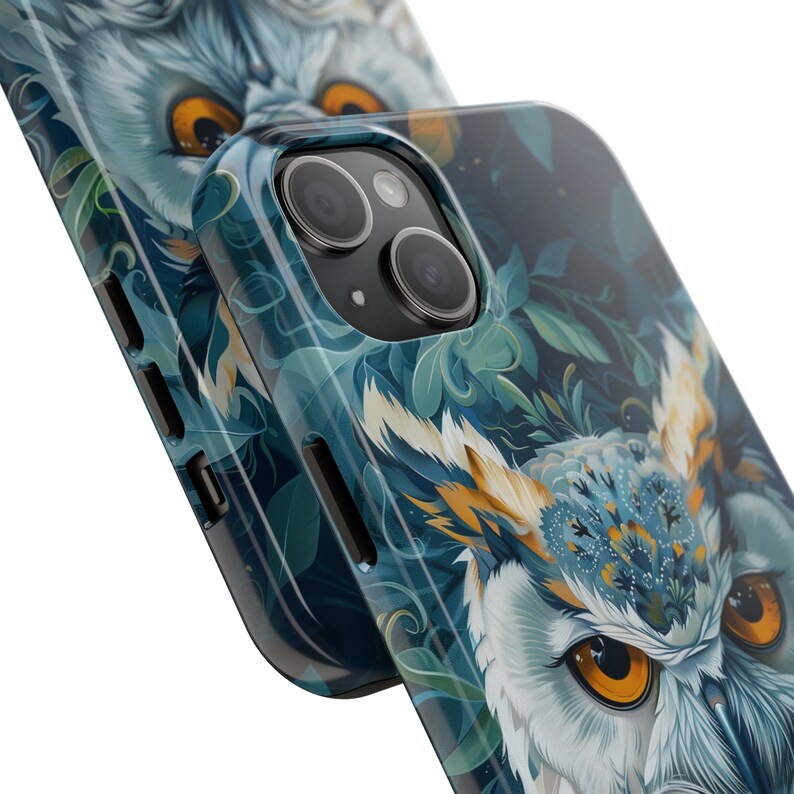 May include: A blue and green phone case with an owl design. The owl has a white face with yellow eyes and a blue and yellow patterned head. The case has a camera lens cutout.