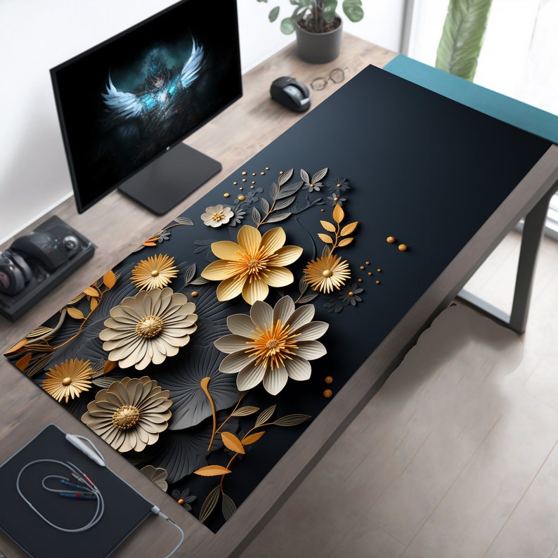 May include: A black desk mat with a floral design featuring gold and white paper flowers. The flowers are arranged in a cluster and have a 3D effect.