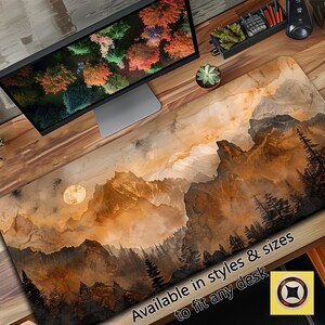 May include: A brown and gold mountain landscape with a full moon in the sky. The mountains are covered in fog and the trees are silhouetted against the sky. The text "Available in styles & sizes to fit any desk" is at the bottom of the image.