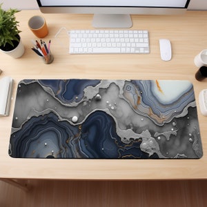 May include: A black and gray marble-patterned mousepad with gold accents. The mousepad has a textured surface and a modern design.