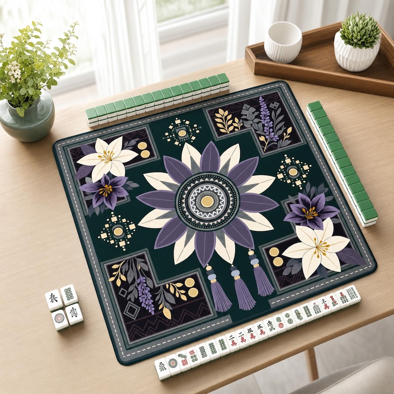 May include: A square mahjong mat featuring a dark green background with a central purple and cream floral mandala design. The mat includes corner floral accents, hanging tassel graphics, and is surrounded by green mahjong tiles and white tiles.
