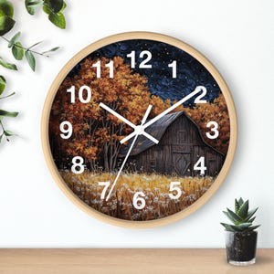 May include: A round wooden wall clock featuring a barn and trees in a field at night. The clock face has white numbers and hands against a dark blue background with white stars.