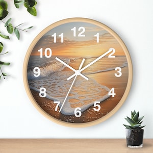 May include: A round wooden wall clock with a beach scene featuring a sunset, waves, and white foam. The clock face has white numbers and hands.