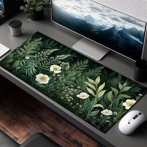 May include: A green and white floral design mousepad with a white computer mouse on a gray desk.