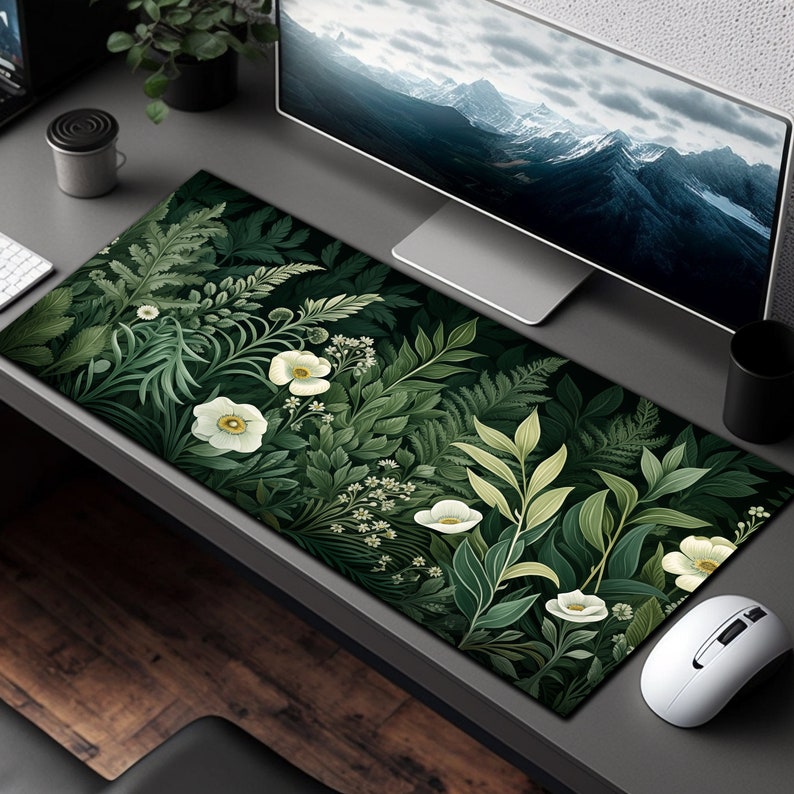 May include: A green and white floral design mousepad with a white computer mouse on a gray desk.