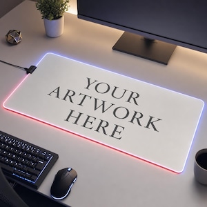 Peut inclure: Un tapis de bureau rectangulaire blanc doté d'une bande lumineuse LED brillante sur tout son périmètre. Le centre du tapis affiche le texte noir "YOUR ARTWORK HERE" dans une police serif. Un câble d'alimentation noir est branché en haut à gauche.
