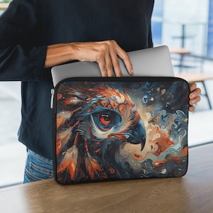 May include: A laptop sleeve with a colorful abstract design featuring a close-up of an owl's eye and feathers. The background is a swirling mix of blue, orange, and brown.