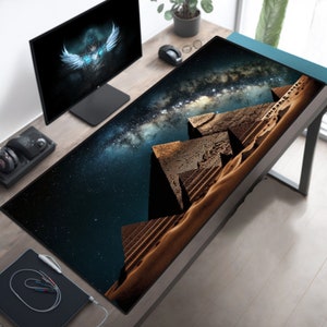 May include: A large black and blue gaming mouse mat with a starry night sky and a desert scene with pyramids in the foreground.