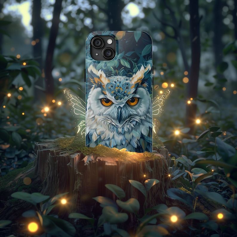 May include: A phone case with a blue and white owl design. The owl has a floral crown and is surrounded by a glowing fairy wing effect. The case is on a tree stump in a forest setting.