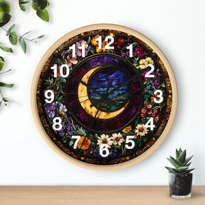 May include: A round clock with a stained glass design featuring a crescent moon, flowers, and leaves. The clock face has Roman numerals and a black hour and minute hand.