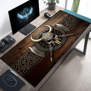 May include: A brown and black gaming mouse mat featuring a skull and crossbones design. The skull is wearing a horned helmet and is encircled by a circular pattern. The mouse mat is made from a soft, durable material and is ideal for gamers of all abilities.