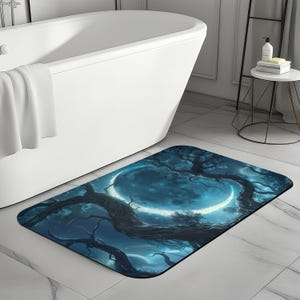 Può includere: Un tappetino da bagno blu e bianco con un design a forma di luna crescente e rami di alberi. Il tappetino è realizzato in materiale morbido e assorbente ed è perfetto per aggiungere un tocco di fantasia al tuo bagno.