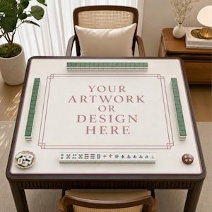 May include: A square mahjong table mat with a white surface and a thin brown border. The center features the text "YOUR ARTWORK OR DESIGN HERE" in brown. Green mahjong tiles are arranged in rows along the edges, with a small dish of tiles and a round marker.