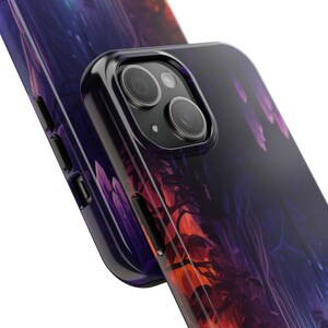 Op de afbeelding: Een paarse en oranje telefoonhoes met een bos sc&egrave;ne en een zwarte camera lens.