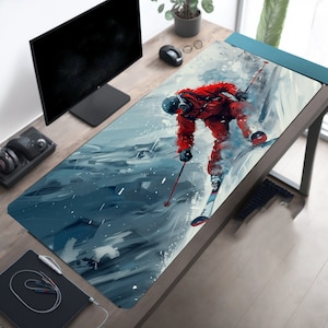 May include: A blue and white abstract design mouse mat with a skier in a red suit and white skis. The skier is in mid-air, with snow flying around them.