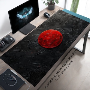 Può includere: Tappetino da scrivania di design astratto nero e rosso con un grande cerchio rosso al centro. Il testo "Disponibile in molti stili e dimensioni per adattarsi a ogni scrivania" è stampato nell'angolo in basso a destra del tappetino.