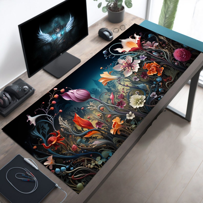 May include: A black and dark blue mousepad with a floral design featuring colorful flowers and vines. The flowers are in shades of pink, red, orange, yellow, and white.
