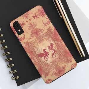 Könnte beinhalten: Eine Handyhülle mit einem Vintage-Design mit zwei roten Drachen in einem dekorativen Rahmen. Der Hintergrund ist in einem verblassten Cremeton gehalten und mit filigranen Blumenmustern verziert.