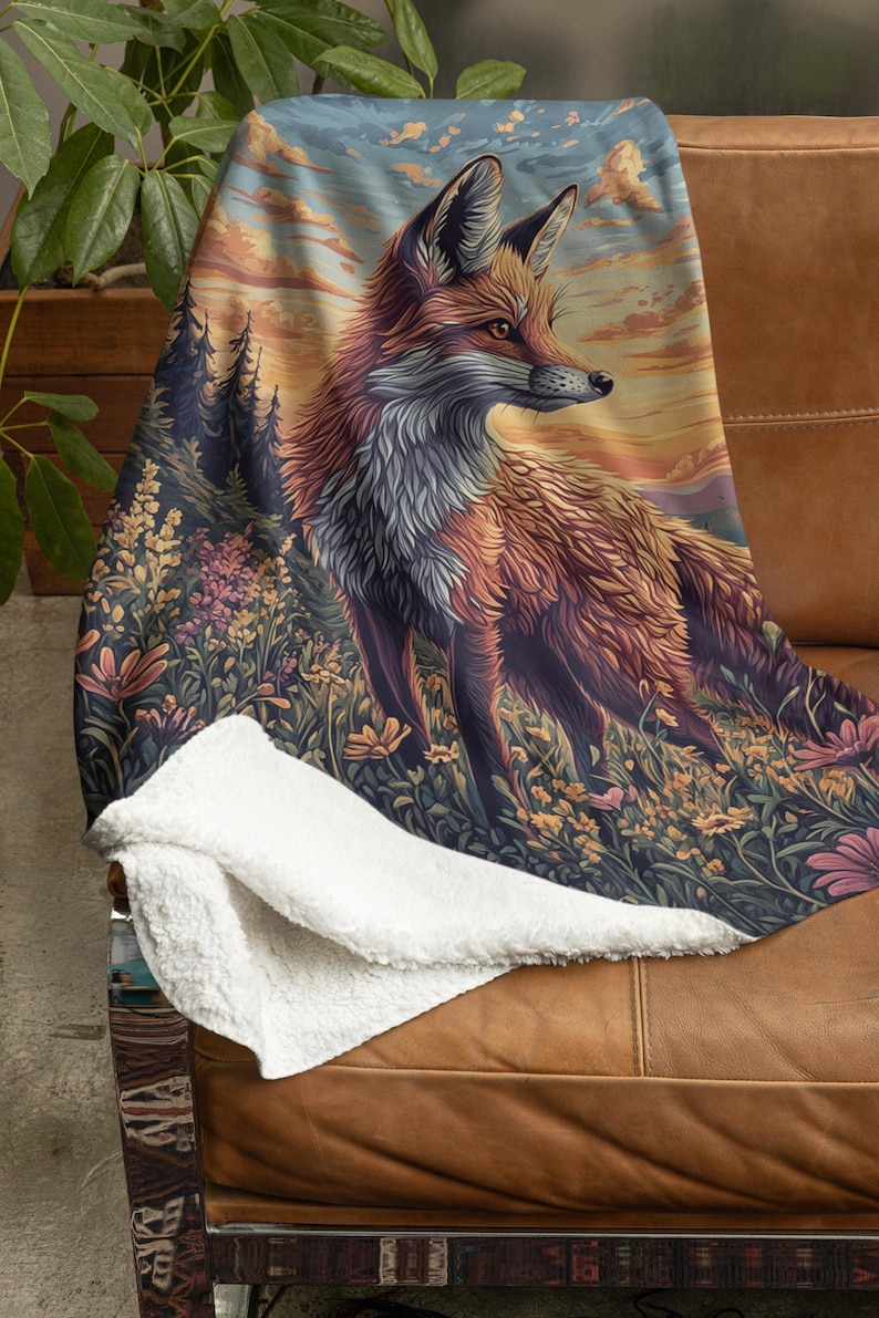 May include: A plush throw blanket with a fox standing in a field of flowers. The fox is facing to the right and has a sunset background.